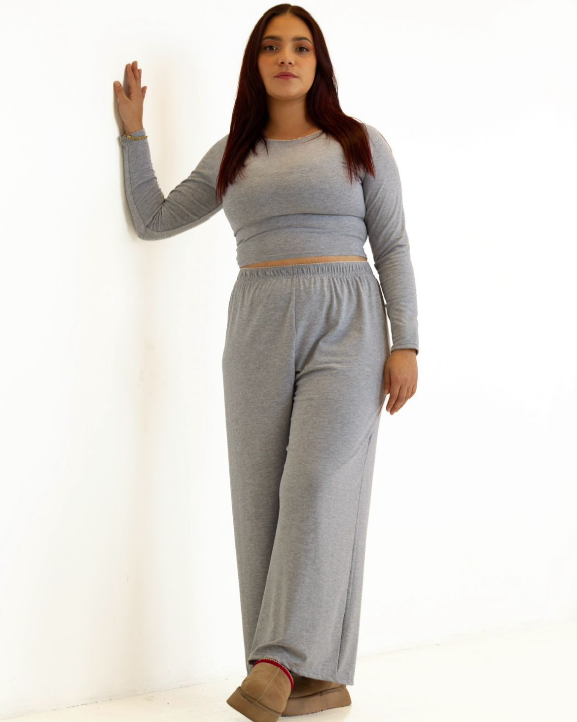 Woman wearing a gray outfit against a white background