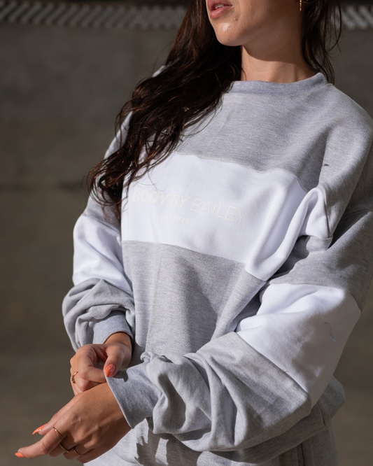 Person wearing a gray sweatshirt against a neutral background