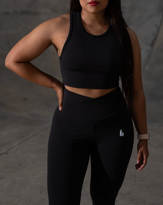 Woman wearing a black athletic outfit against a dark background