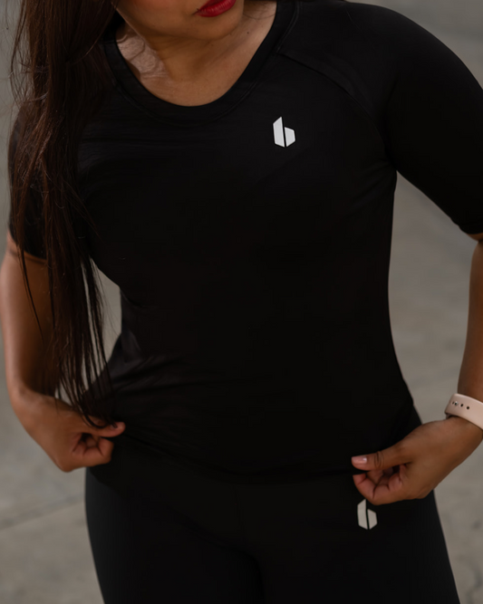 Woman wearing a black t-shirt with a logo on a gray background